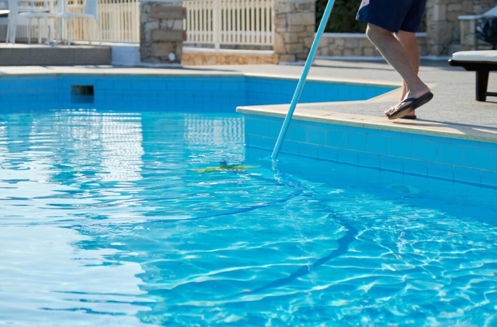 Alotta Pool Service team member performing pool maintenance in Lee County, FL, ensuring cleanliness.